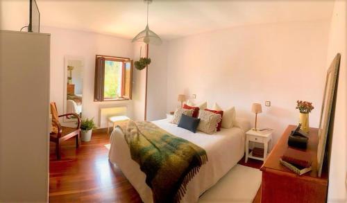 a bedroom with a bed and a table and a mirror at Casa Hijuela in Concejero