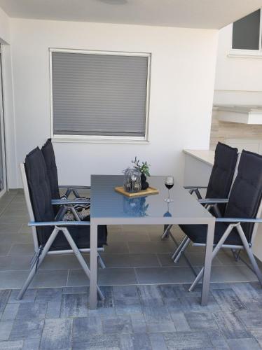 a dining room table with chairs and a window at Dolphin view with a pool by the beach in Mandre