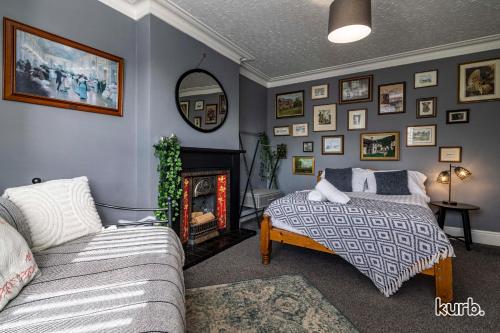 a bedroom with a bed and a couch and a fireplace at Carlton Hill House - 5 Bedroom House with Parking in Nottingham