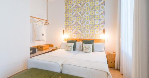 una camera da letto con letto, lenzuola e cuscini bianchi di Bed and Chic a Las Palmas de Gran Canaria