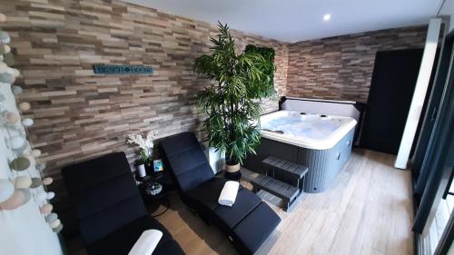 Saint-Laurent-de-la-PréeにあるCasa Aix Keys avec jacuzzi privatif proche plages et Golfの黒い椅子が置かれたリビングルームのジャグジー浴槽