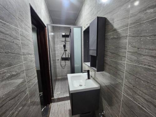 a bathroom with a sink and a mirror at Frennin Court in Accra