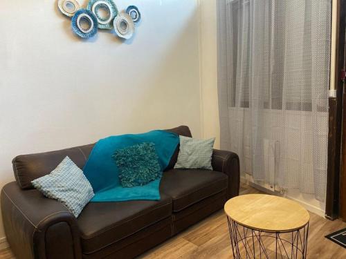 un salon avec un canapé marron et une table dans l'établissement La Ptit Sophie - Conciergerie Leroy, à Boulogne-sur-Mer