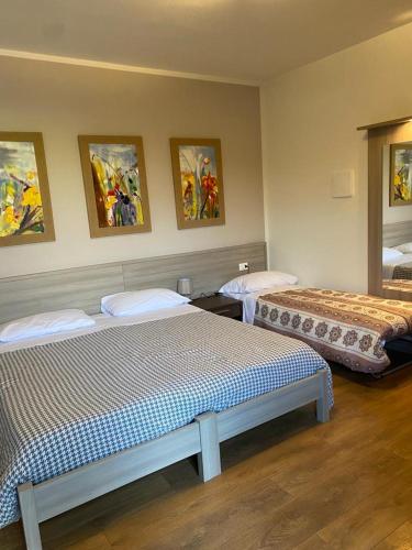 Habitación con 2 camas y pinturas en la pared. en Agriturismo da Mea en Santorso