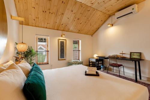 ein Schlafzimmer mit einem großen weißen Bett und einem Schreibtisch in der Unterkunft Villa De Pastry Vesta Collections in Ho-Chi-Minh-Stadt