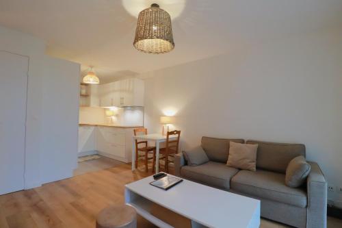 un salon avec un canapé et une table dans l'établissement Olivia - T2 - confort - wifi- parking, à Vannes