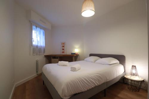 une chambre avec un lit avec deux serviettes dessus dans l'établissement Olivia - T2 - confort - wifi- parking, à Vannes