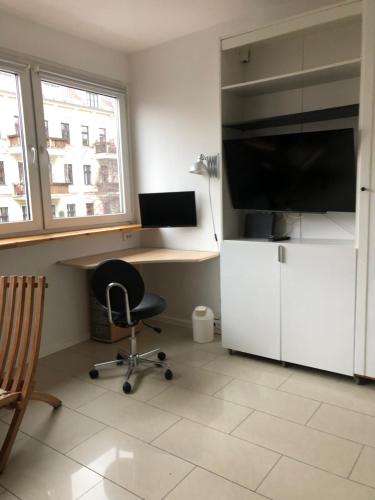 a room with a desk and a chair and a television at Sky view Neukölln in Berlin