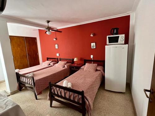 a hotel room with two beds and a refrigerator at La Cibeles in Miramar