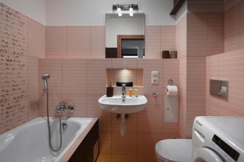 łazienka z umywalką, wanną i toaletą w obiekcie Apartament Zakątek Kudowa Przytulny w Kudowie Zdroju
