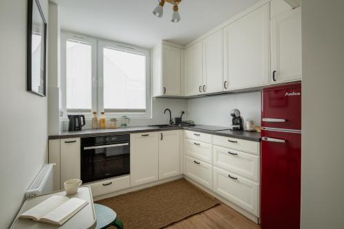 kuchnia z białymi szafkami i czerwoną lodówką w obiekcie Apartament Zakątek Kudowa Przytulny w Kudowie Zdroju