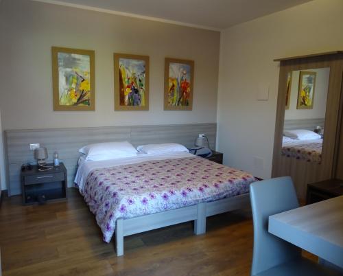 a bedroom with a bed and three pictures on the wall at Agriturismo da Mea in Santorso