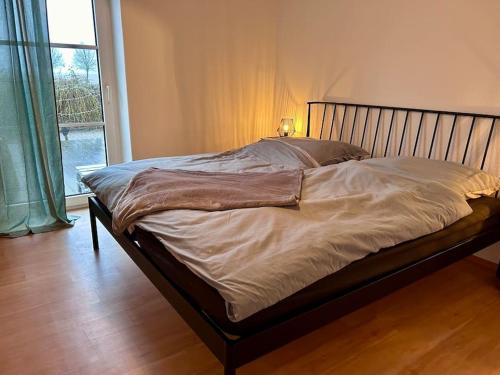 - un grand lit dans une chambre avec fenêtre dans l'établissement Ferienhaus am Poggensee, à Bad Oldesloe