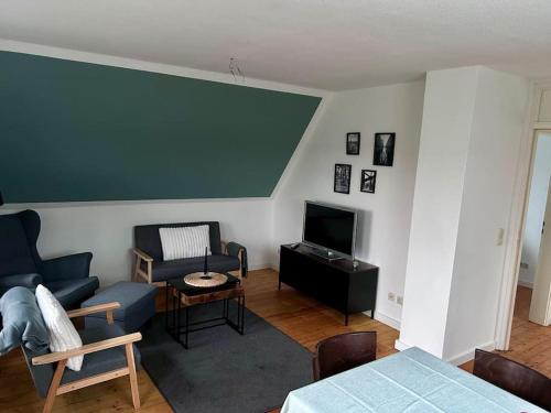 un salon avec un canapé bleu et une télévision dans l'établissement Ferienhaus am Poggensee, à Bad Oldesloe