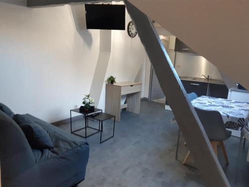 un salon avec un canapé, une table et une télévision dans l'établissement Studio N°6 Boston Conciergerie Leroy, à Boulogne-sur-Mer