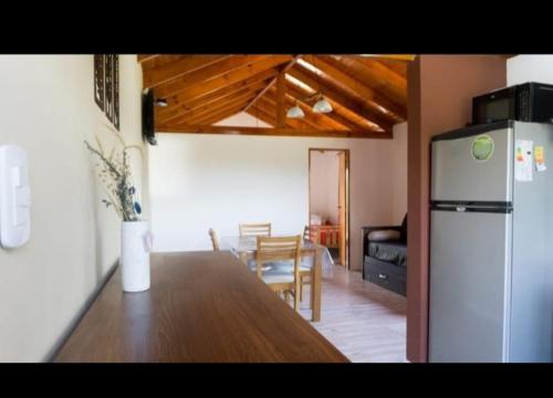 a kitchen and dining room with a table and a refrigerator at Cabañas Del Rio in San Francisco del Monte de Oro