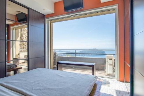 1 dormitorio con cama y vistas al océano en Appartement spacieux - Vue mer panoramique, en Villefranche-sur-Mer