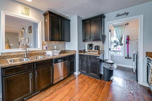 a kitchen with brown cabinets and a wooden floor at Family-Friendly Clarksville Home with Fire Pit! in Oak Grove