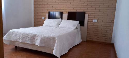 サン・ラファエルにあるComplejo Mallorca San Rafaelの部屋にある白いシーツと枕が置かれたベッド