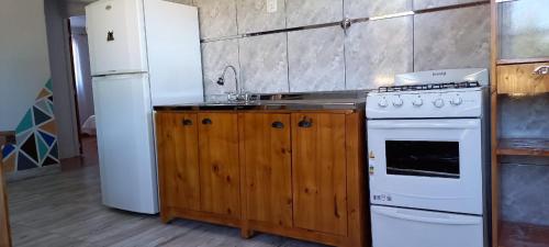サン・ラファエルにあるComplejo Mallorca San Rafaelのキッチン(白い家電製品、木製キャビネット付)