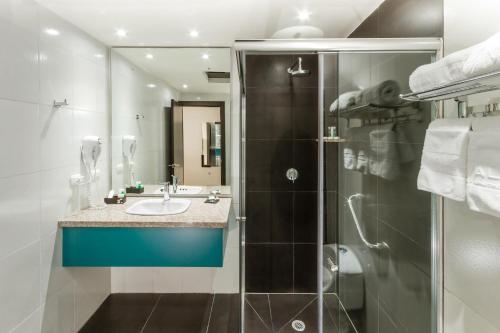 a bathroom with a sink and a shower at Hotel Valgus in Cuenca