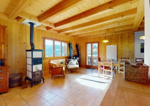 sala de estar con estufa de leña y mesa en Chalet authentique avec magnifique vue en Cerniat