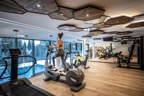 a woman exercising on a treadmill in a gym at Wellness Hotel Gran Risa***S in La Villa