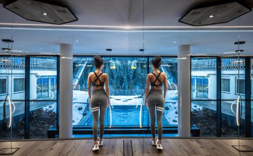 two girls in bikinis looking out of a window at Wellness Hotel Gran Risa***S in La Villa