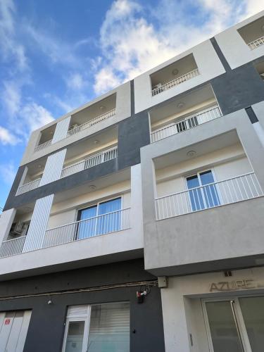 un edificio blanco con ventanas y un cielo azul en Azure FOUR en Żurrieq