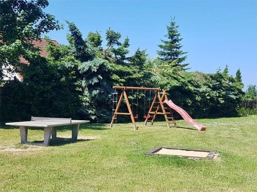 a park with a playground with a bench and a slide at Lütt Matten de Has - Sünnenkieker WE2 - ABC364 in Beckerwitz