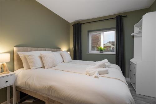 Beach Apartment - 2 Bedrooms Free WiFi Parking في كليفليز: غرفة نوم مع سرير أبيض كبير مع نافذة