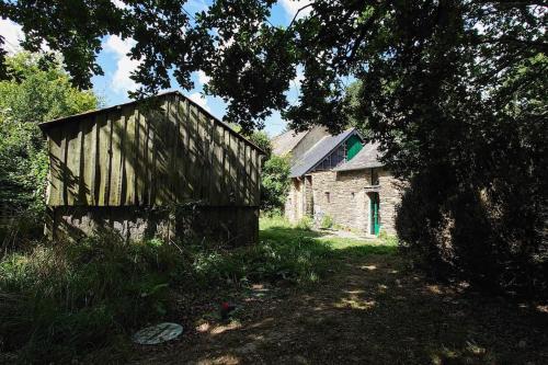 un ancien bâtiment en pierre au milieu d'un champ dans l'établissement Longère tinyhouse avec son jardin-forêt, à Saint-Just