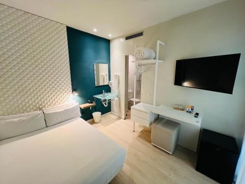 een slaapkamer met een bed, een bureau en een televisie bij Urban Sea Hotel Atocha 113 in Madrid