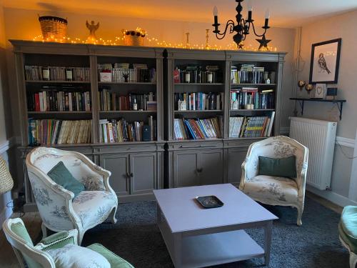 un soggiorno con due sedie e una libreria con libri di Chambre 2 a Chalmazel Jeansagniere