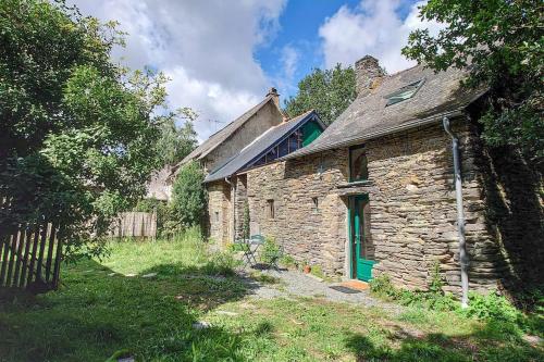 une ancienne maison en pierre avec une porte verte dans l'établissement Longère tinyhouse avec son jardin-forêt, à Saint-Just