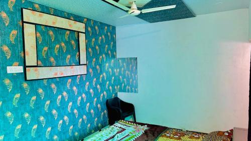 a bedroom with a blue wall with a peacock wallpaper at Radhey Krishna home stay in Mathura