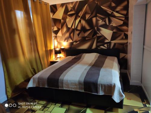 a bedroom with a bed with a geometric wall at DJUNEK in Mielno