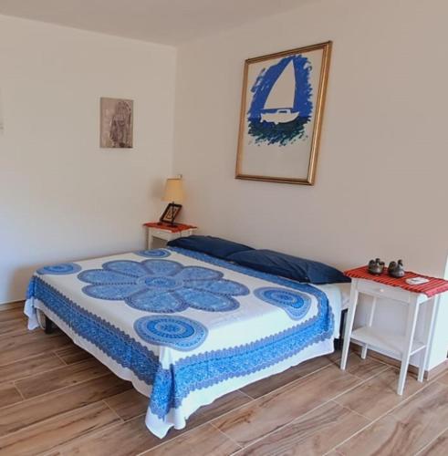 een slaapkamer met een bed met een blauwe en witte quilt bij La Civetta - Relax tra verde e mare a 10 minuti da Sestri Levante in Casarza Ligure