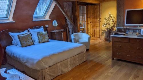 a bedroom with a bed and a desk and a television at La Maison d'Artgile in Zimmersheim