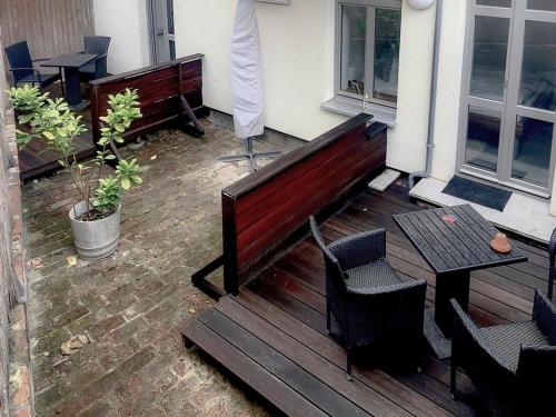 a wooden bench and a table on a patio at Luv an der Nikolaikirche - ABC85 in Wismar