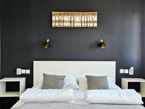 1 dormitorio con 1 cama blanca y 2 luces en la pared en Cozy House Zivko with Balcony, en Lagos de Plitvice