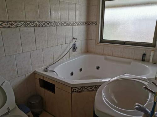 a bathroom with a tub and a toilet and a sink at CASA CON QUINCHO in Ancud