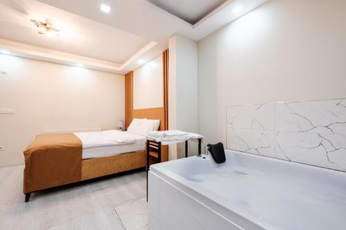 - une chambre avec un lit et une baignoire dans l'établissement Cozy Residence w Jacuzzi Balcony 5 min to Taksim, à Istanbul