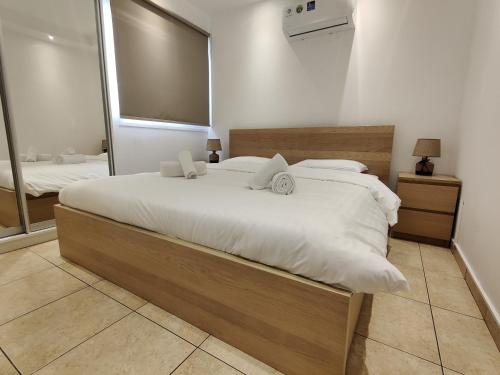 a bedroom with a large bed and a large mirror at Maestro II Apartment in Larnaka