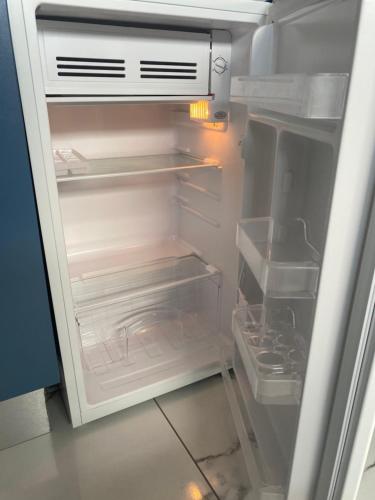 an empty refrigerator with its door open in a kitchen at Rollers Rest Guesthouse in Boksburg