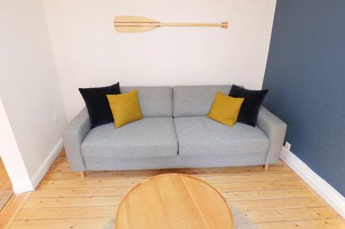 a living room with a couch with yellow pillows at NEU! Ferienhaus Kleine Auszeit - Nur für Feriengäste - ABC1 in Wismar