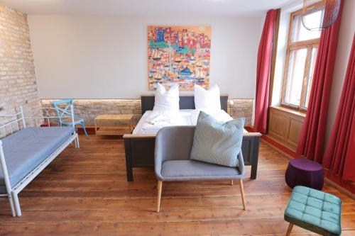 une chambre avec un lit, un canapé et une chaise dans l'établissement Neue Wasserkunst - Premium Gruppenferienwohnung - ABC354, à Wismar