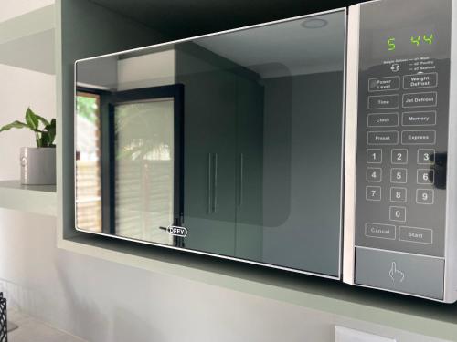 d'un four micro-ondes sur un mur avec une fenêtre. dans l'établissement Rollers Rest Guesthouse, à Boksburg