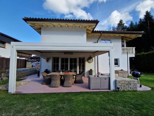 a white pergola with a table and chairs in a yard at DSW Ferienhaus in Oberperfuss