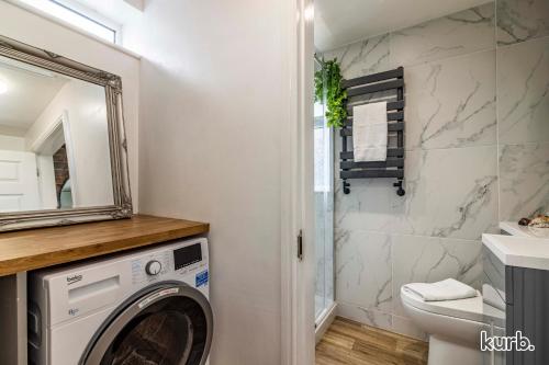 a bathroom with a washing machine and a mirror at Carlton Hill House - 5 Bedroom House with Parking in Nottingham